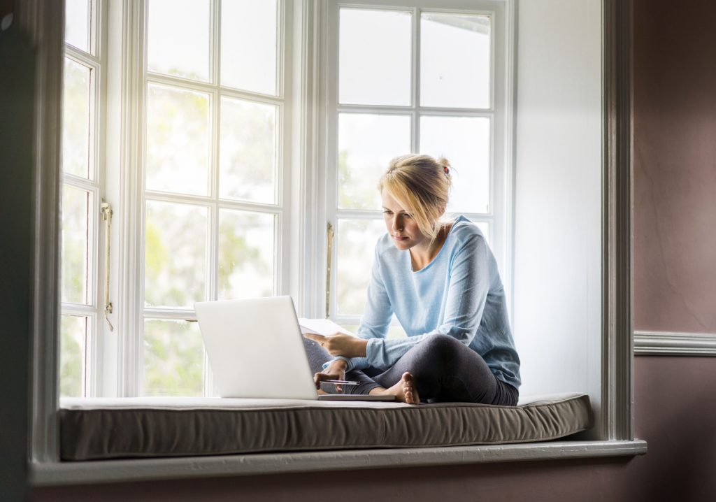 woman using her laptop to tour a home virtually